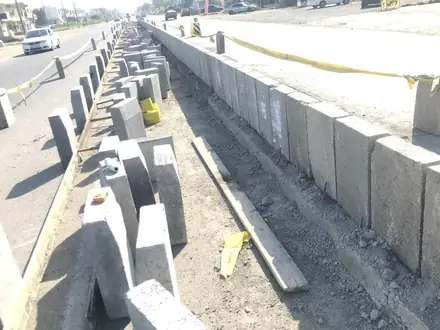 A run of precast concrete units for kerb and central reserve down the middle of the carriageway