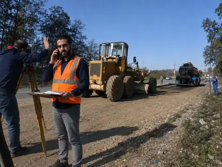 Survey work beside the grader during realignment