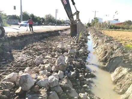 Clearing the stone-lined channel with the excavator
